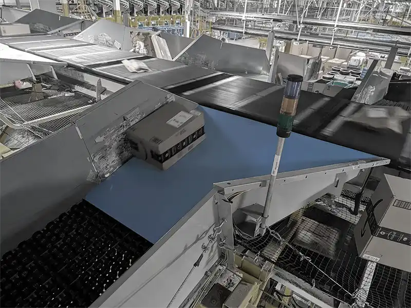 IPX PG below a package on a conveyor belt system at an Amazon Distribution Center.