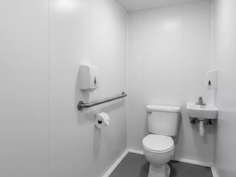 A portable bathroom lined with white FRP panels.
