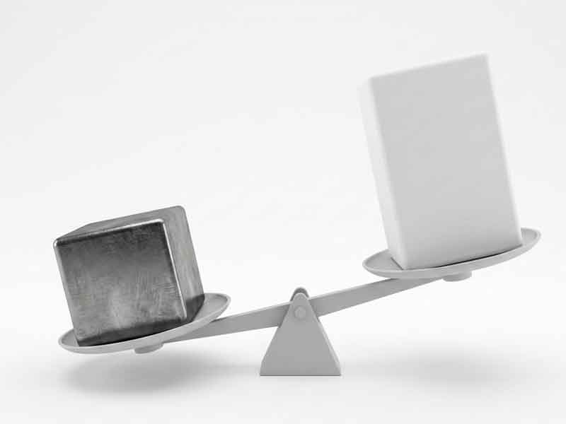 Photo of metal and plastic blocks on a scale, illustrating that metal weighs more than plastic.